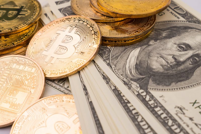 golden-bitcoins-of-new-digital-money-on-banknotes-2022-12-16-03-11-48-utc.jpg